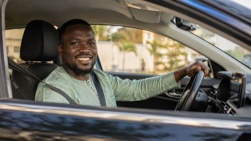 Chauffeur YOKHLA souriant au volant de son véhicule